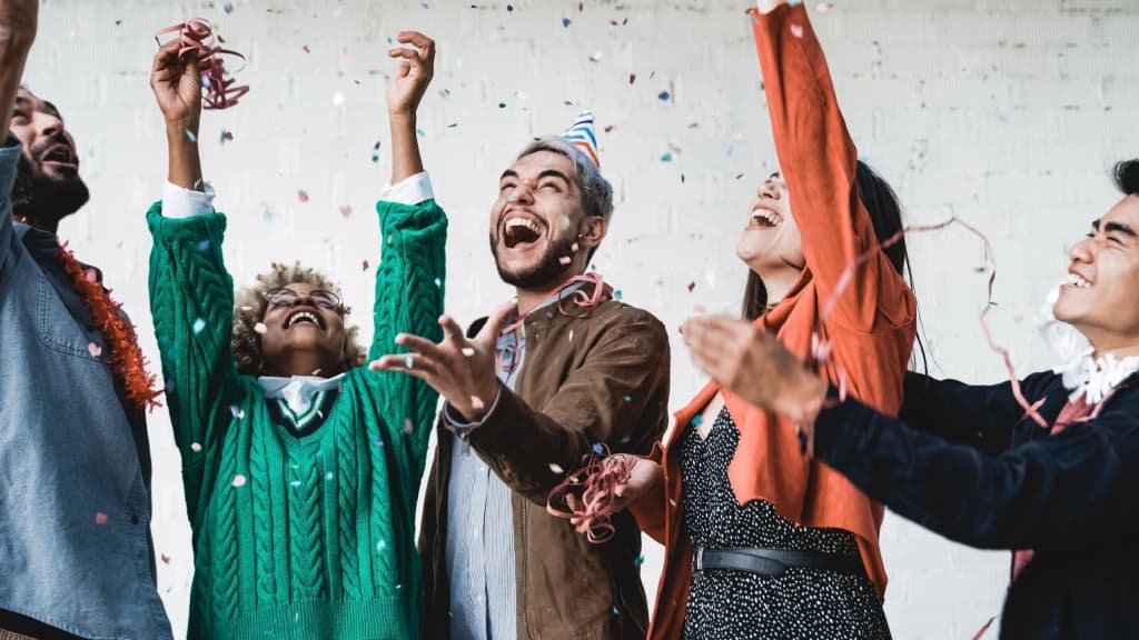 Group of young people celebrating with confetti.