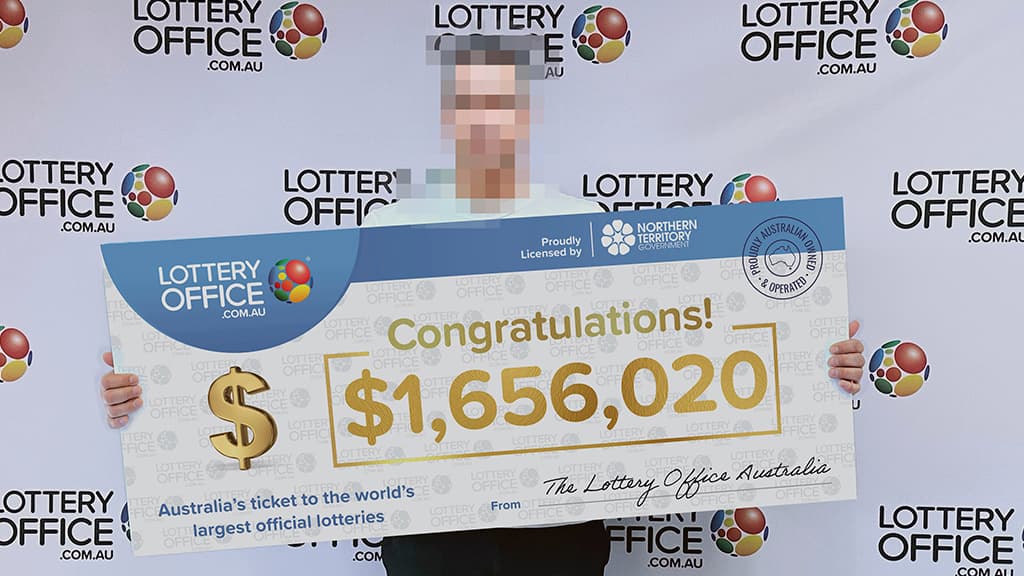 Man holding a winning cheque.