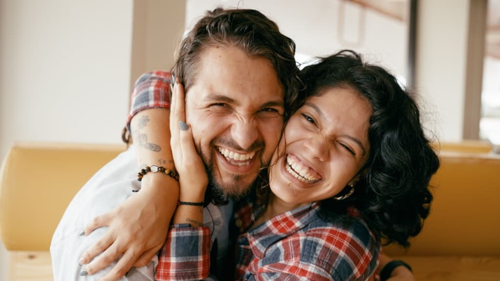 Close up of couple hugging happily.