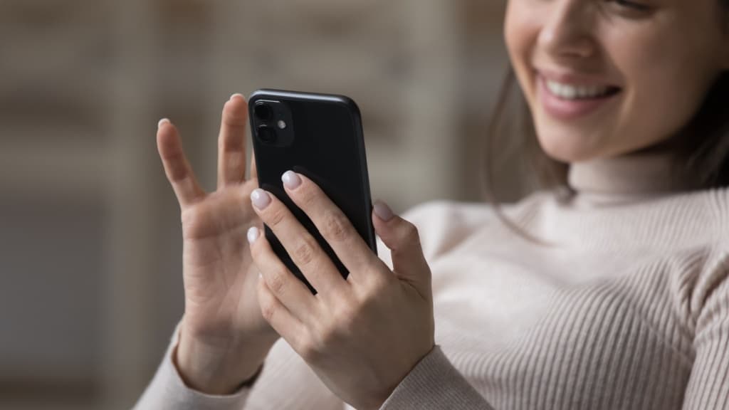 Close up cropped shot happy attractive woman use modern smartphone at home.
