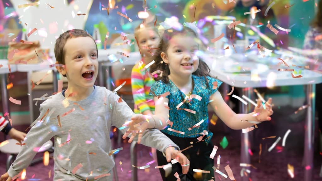 Children at a party surrounded by confetti.